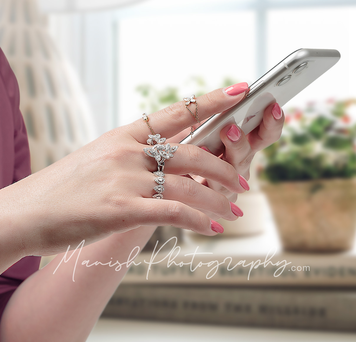 Jewellery studded hand holding a phone